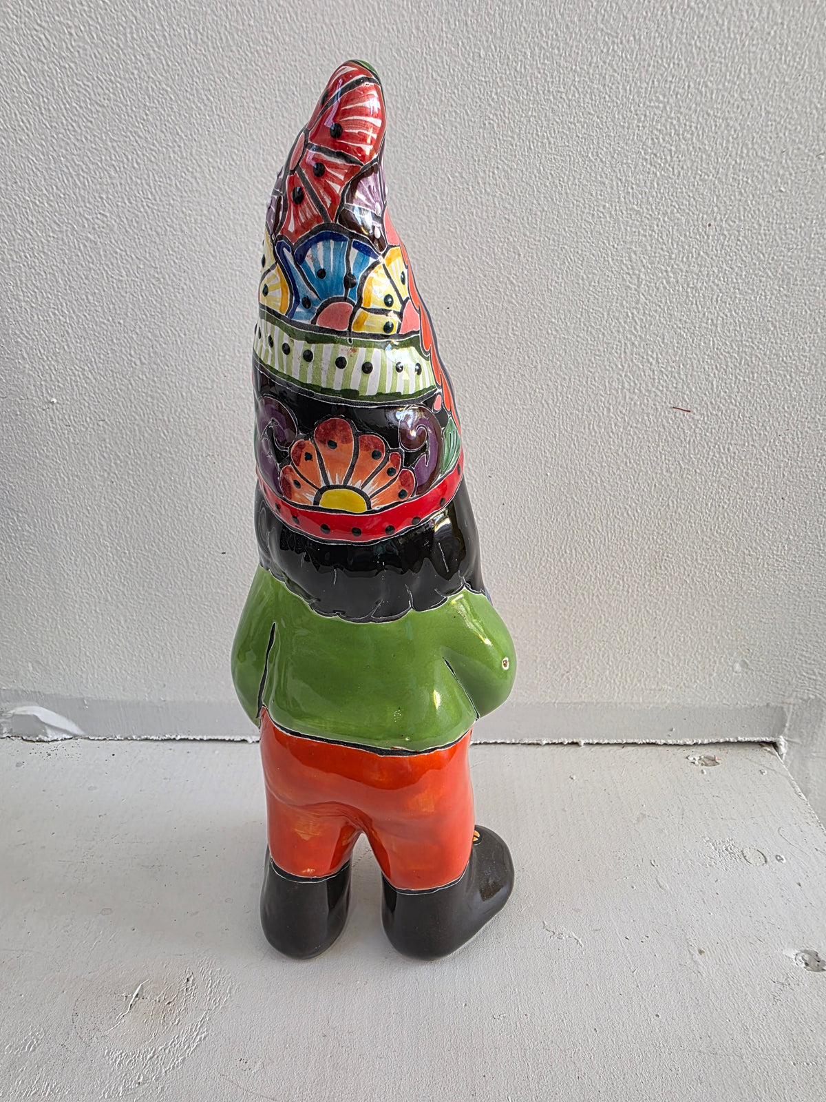Colorful gnome figurine with a patterned hat on a white surface