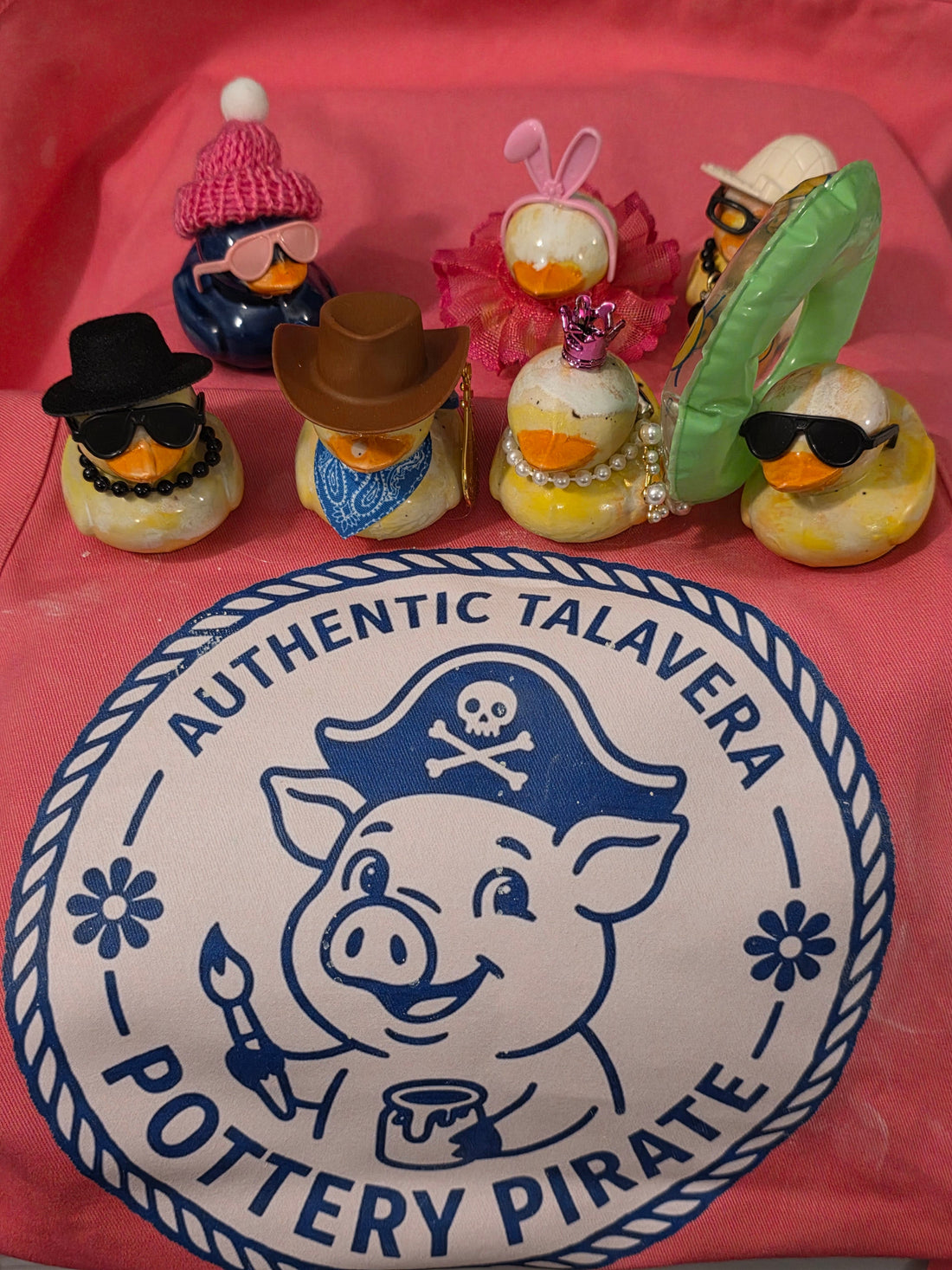 ducks in outfits on an apron with pig logo of pottery pirate