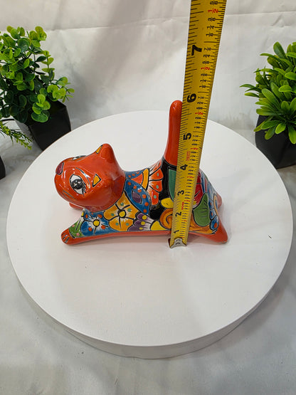 Decorative  CAT shaped object with colorful patterns on a white surface, measured by a yellow tape measure