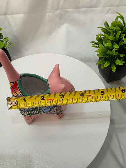 Measurement of a decorative cat planter with a tape measure on a white surface.