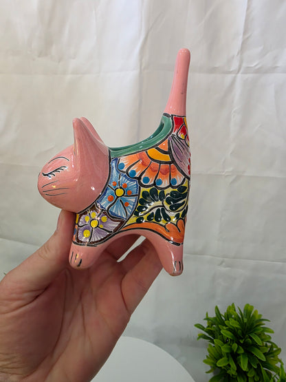 Hand holding a colorful ceramic cat planter against a white background