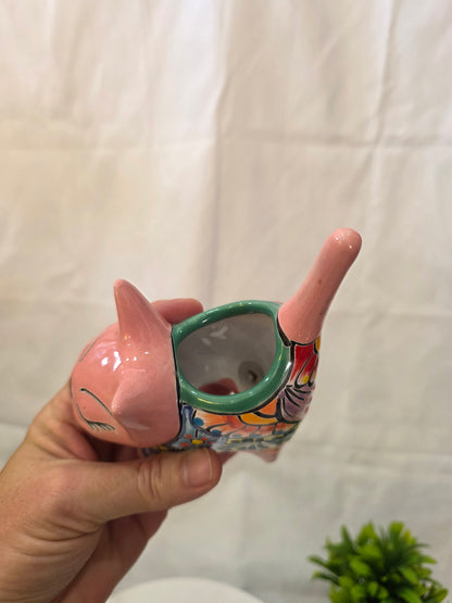 Decorative ceramic cat planter with colorful design held by a hand on a white background