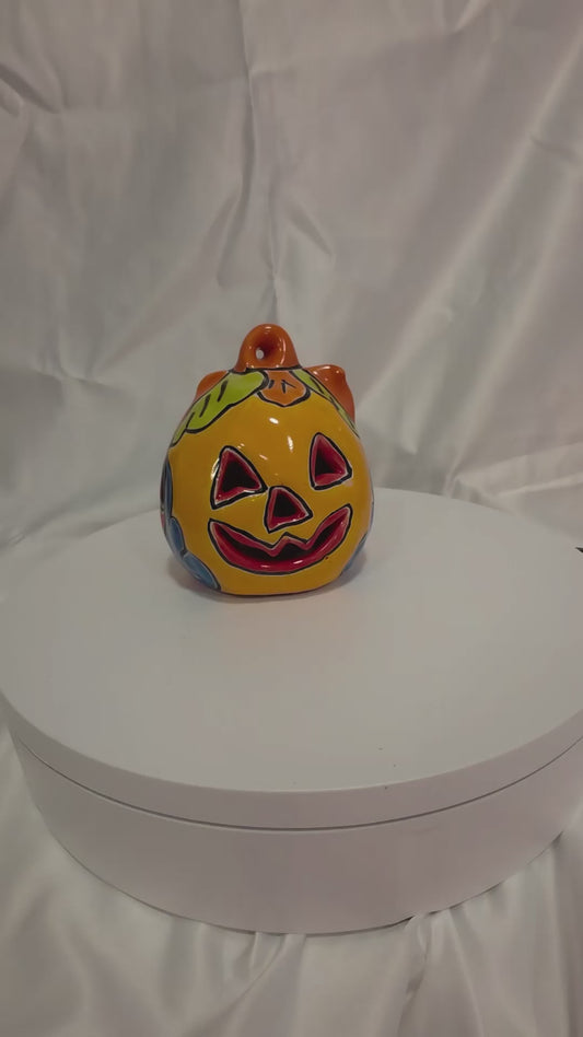 orange and red talavera painted pumpkin on a turntable with a white background